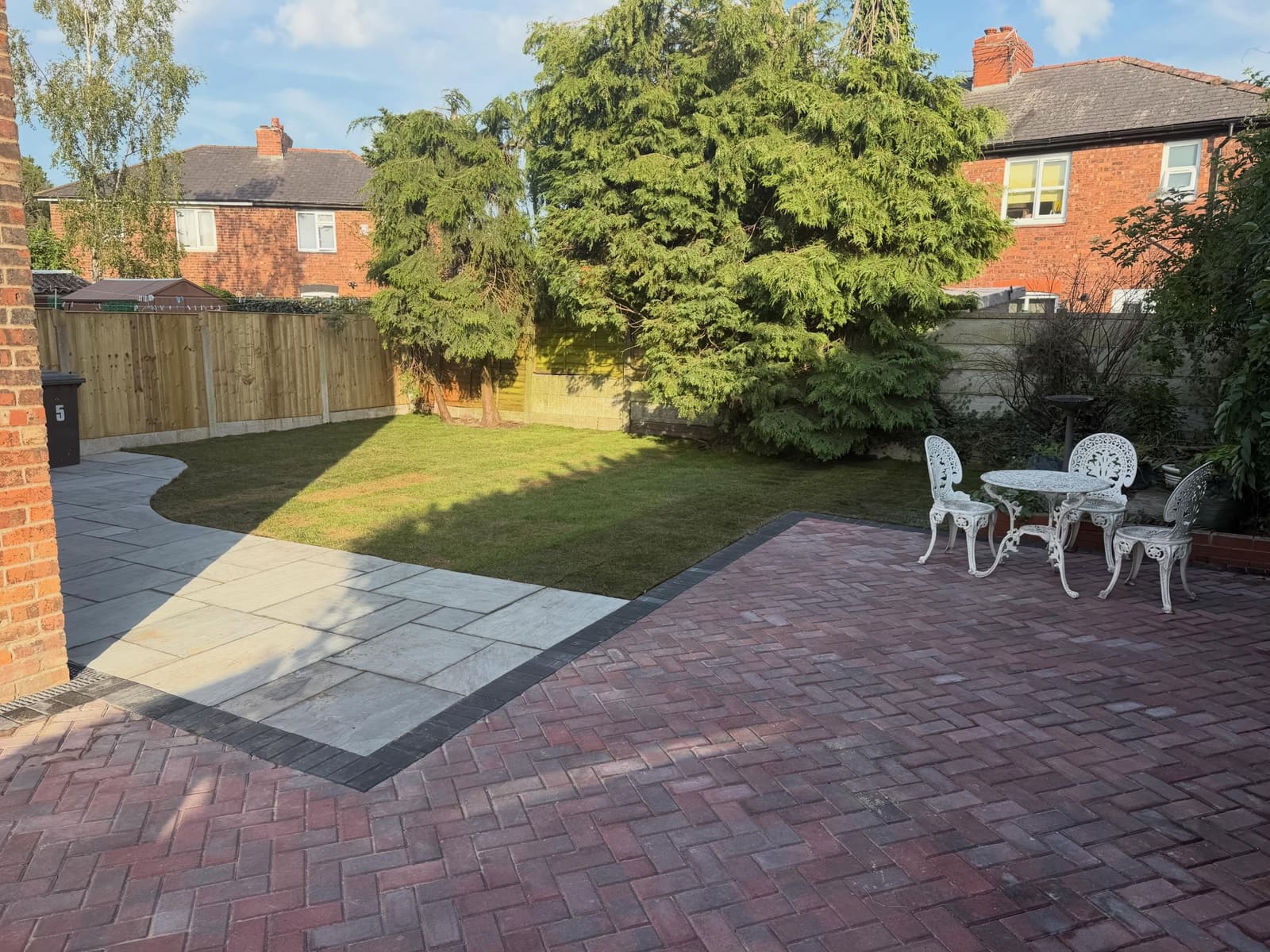 Red herringbone seating area linked to sandstone path and new turf