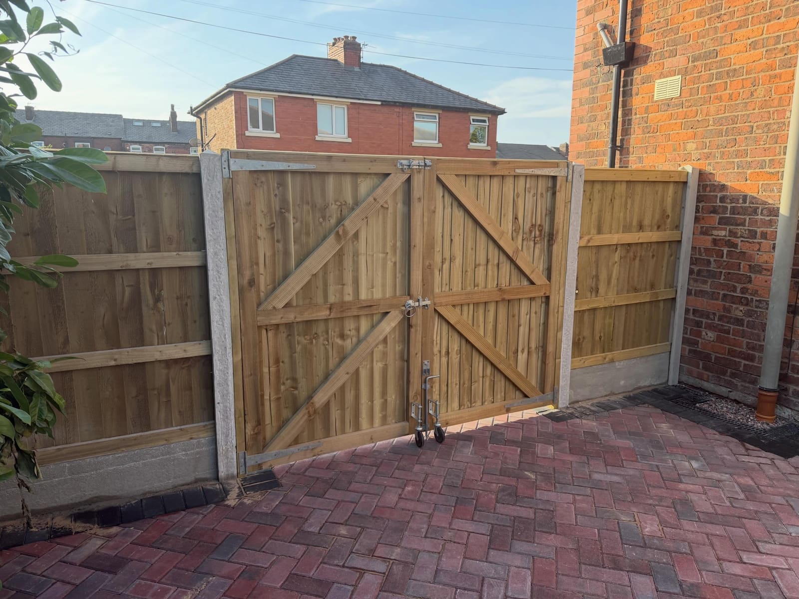 Double closeboard driveway gates on wheels with herringbone block paving