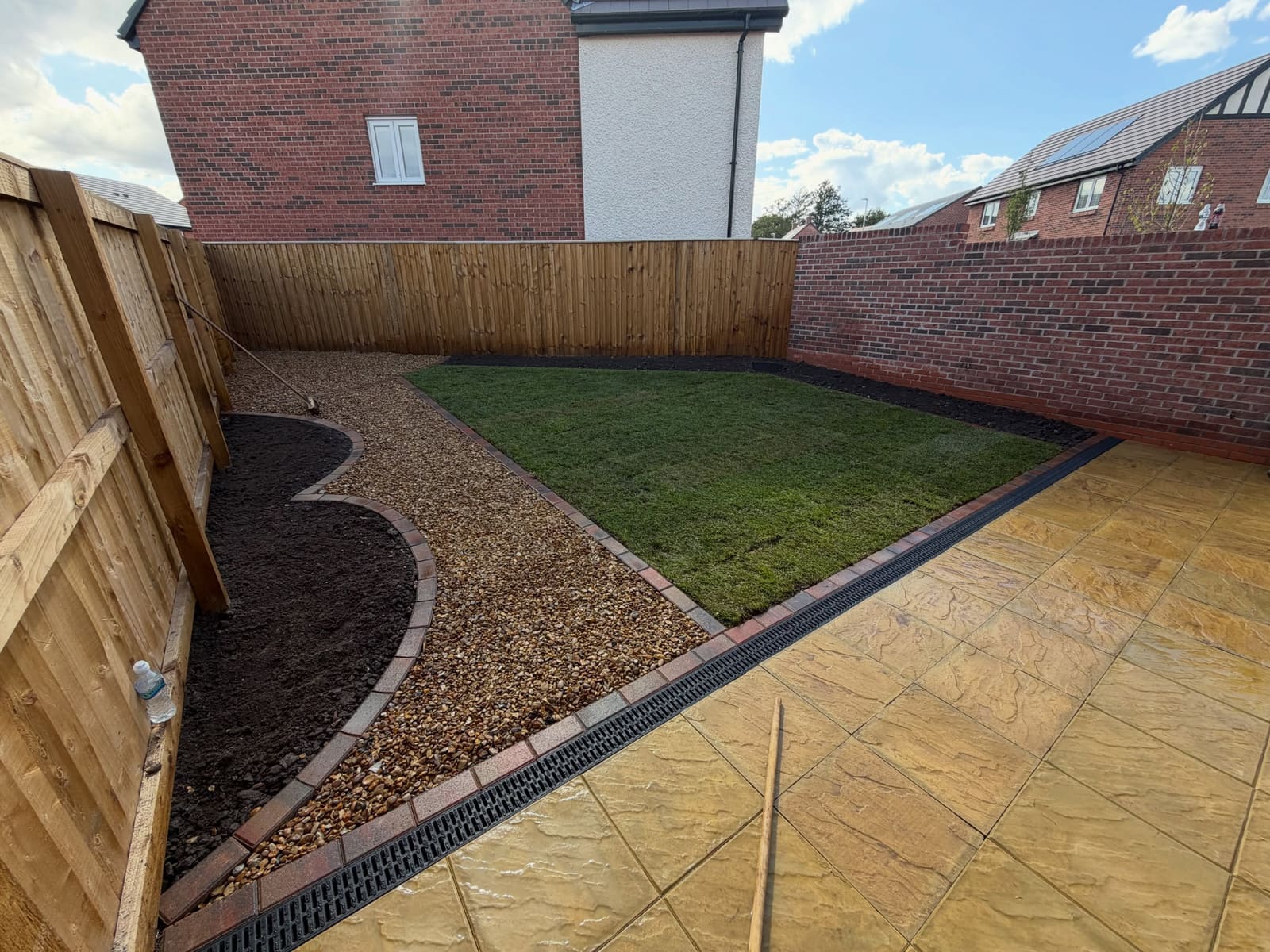 Golden riven slab patio with shingle borders and curved brick-edged bed