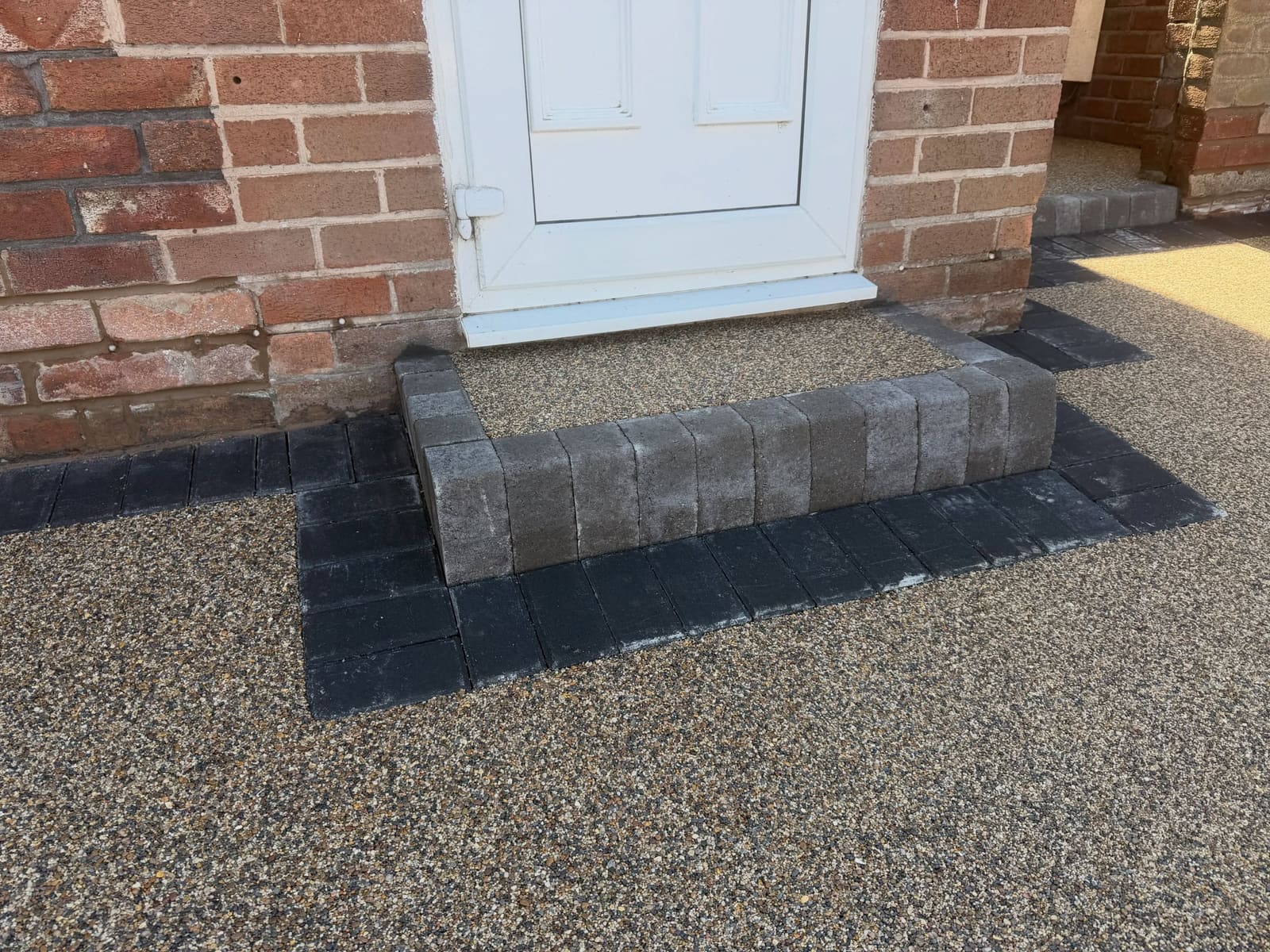 Golden resin bound doorstep finished with vertical charcoal block risers
