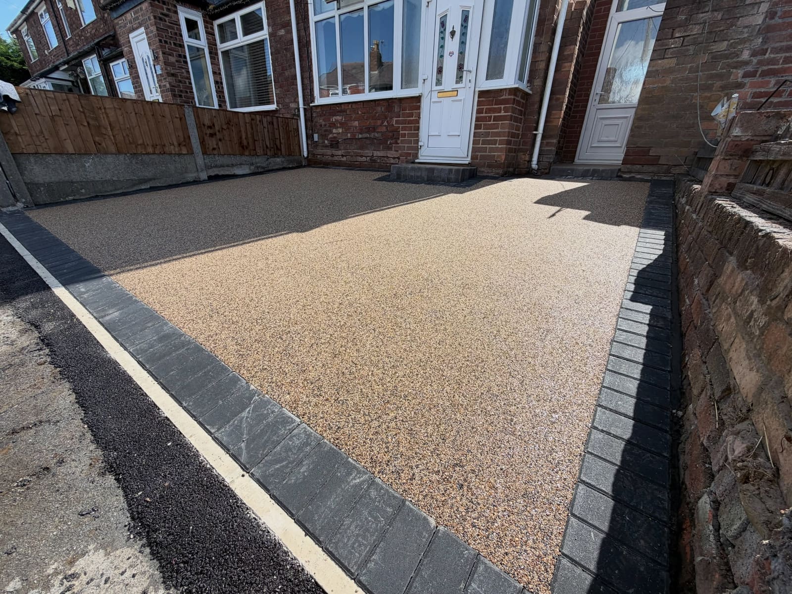 Permeable buff resin bound driveway framed by charcoal block soldiers Greater Manchester